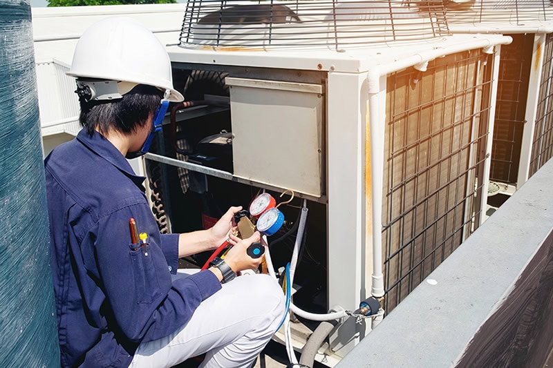Why Is a Commercial AC Tune-Up Important? A technician fixing an air conditioner.